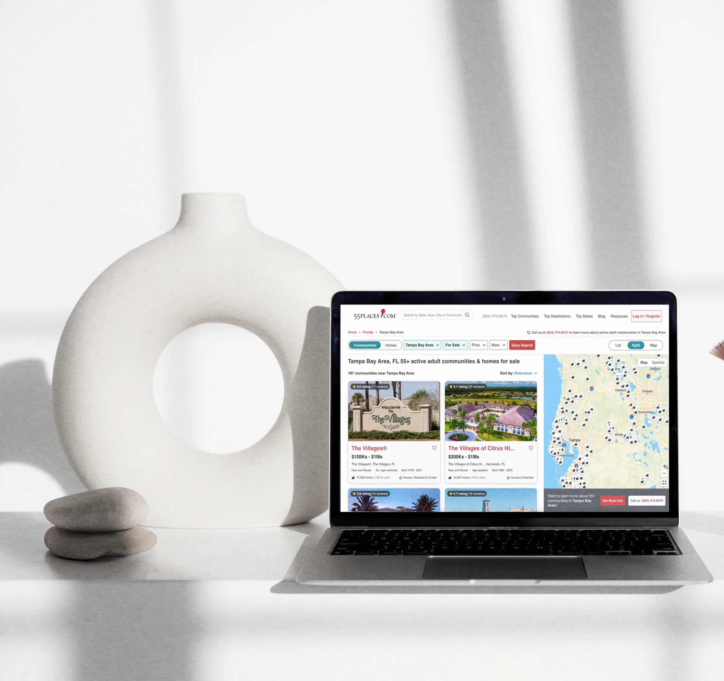 A laptop on a bright desk showing the redesigned 55places Tampa Bay Area destination page — filter bar, community result cards, and the map in split view
